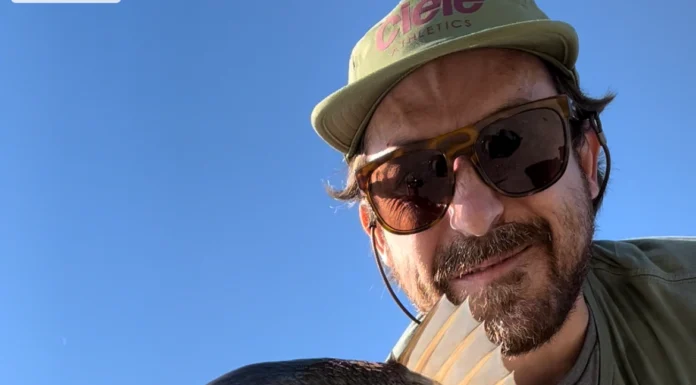 915 | How a Music Producer Built a Fly Fishing Podcast from Scratch with Pablo Signori Pablo Signori holding a large fish while fly fishing near a coastal city