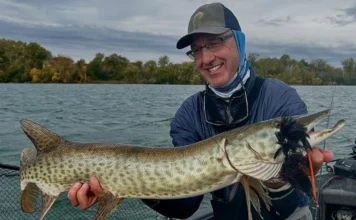 Hunting with a Fly #2 | Rick Kustich’s Musky Fly Fishing Playbook Rick Kustich holding a musky caught on a fly with a large streamer in its mouth