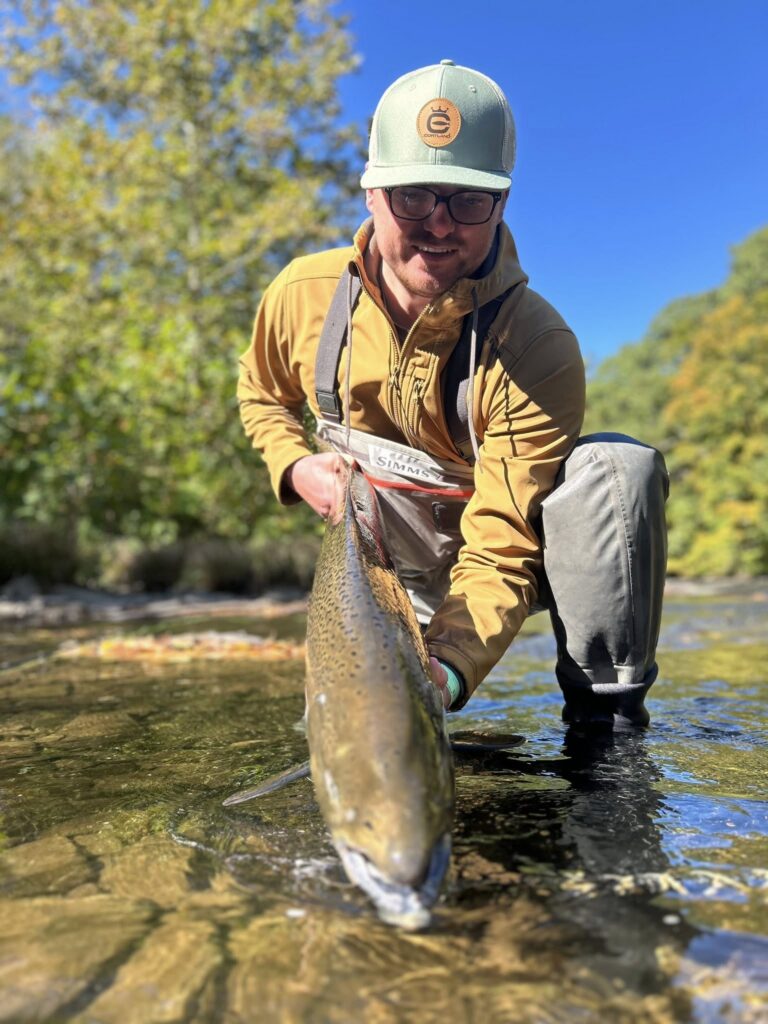 Angler releasing a brown trout after matching fly line design to rod and fishing conditions.