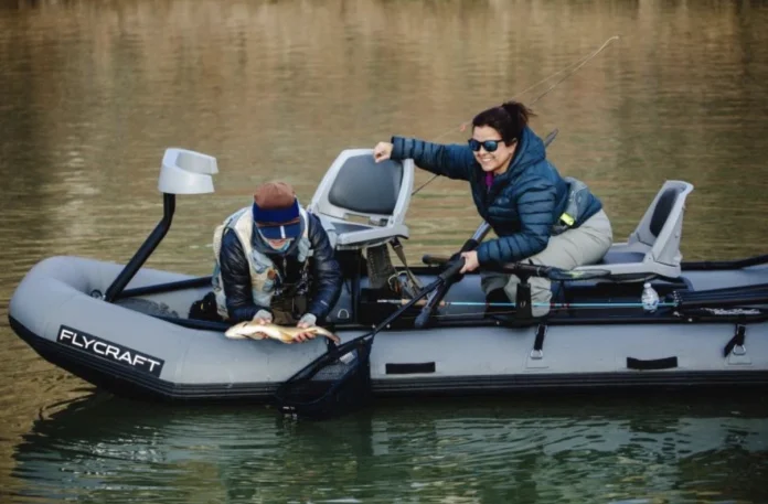Trisha Valdez landing a trout from a Flycraft boat while fly fishing New Mexico